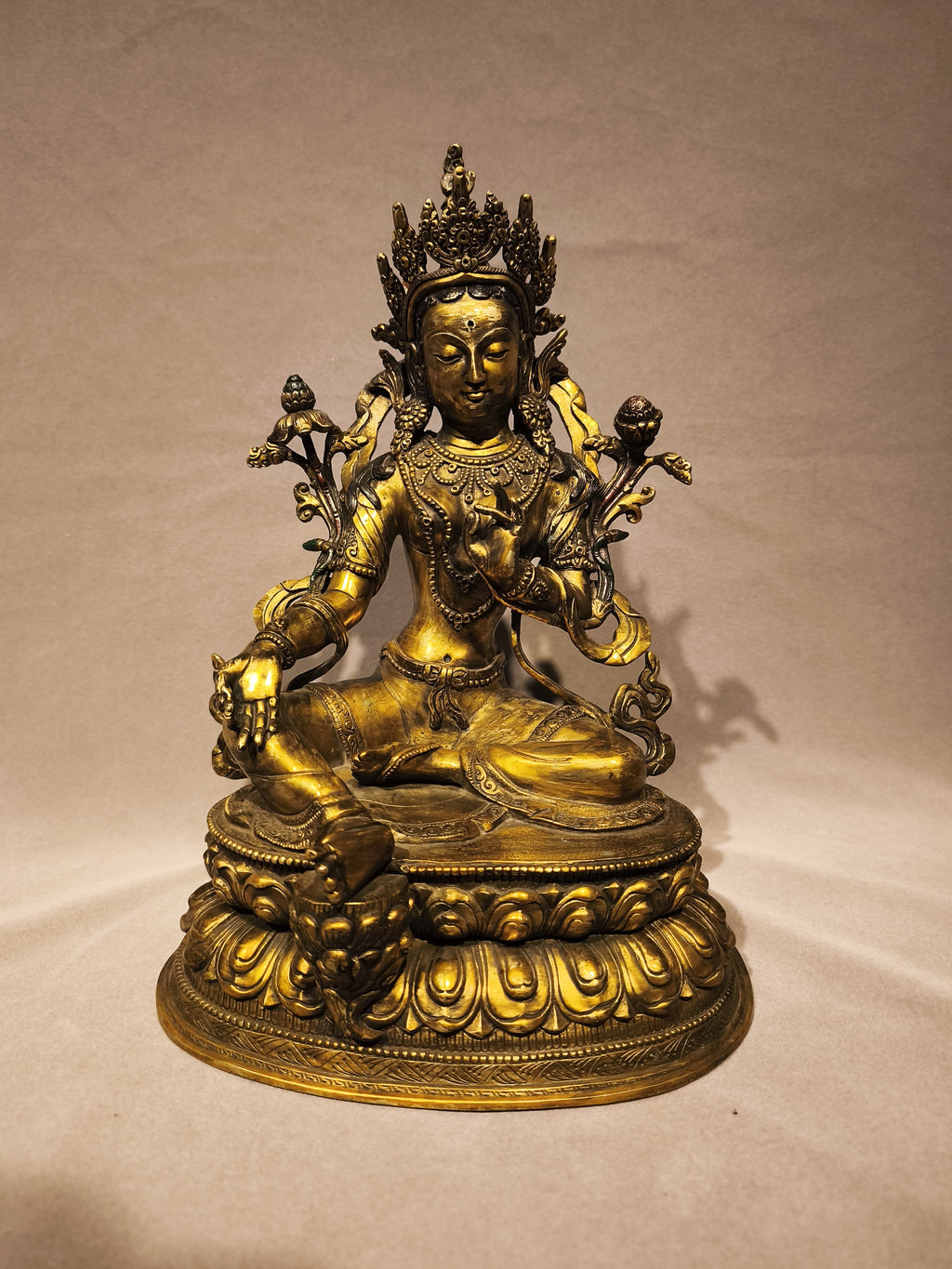 Frontal view of the copper Green Tara on her pedestal.