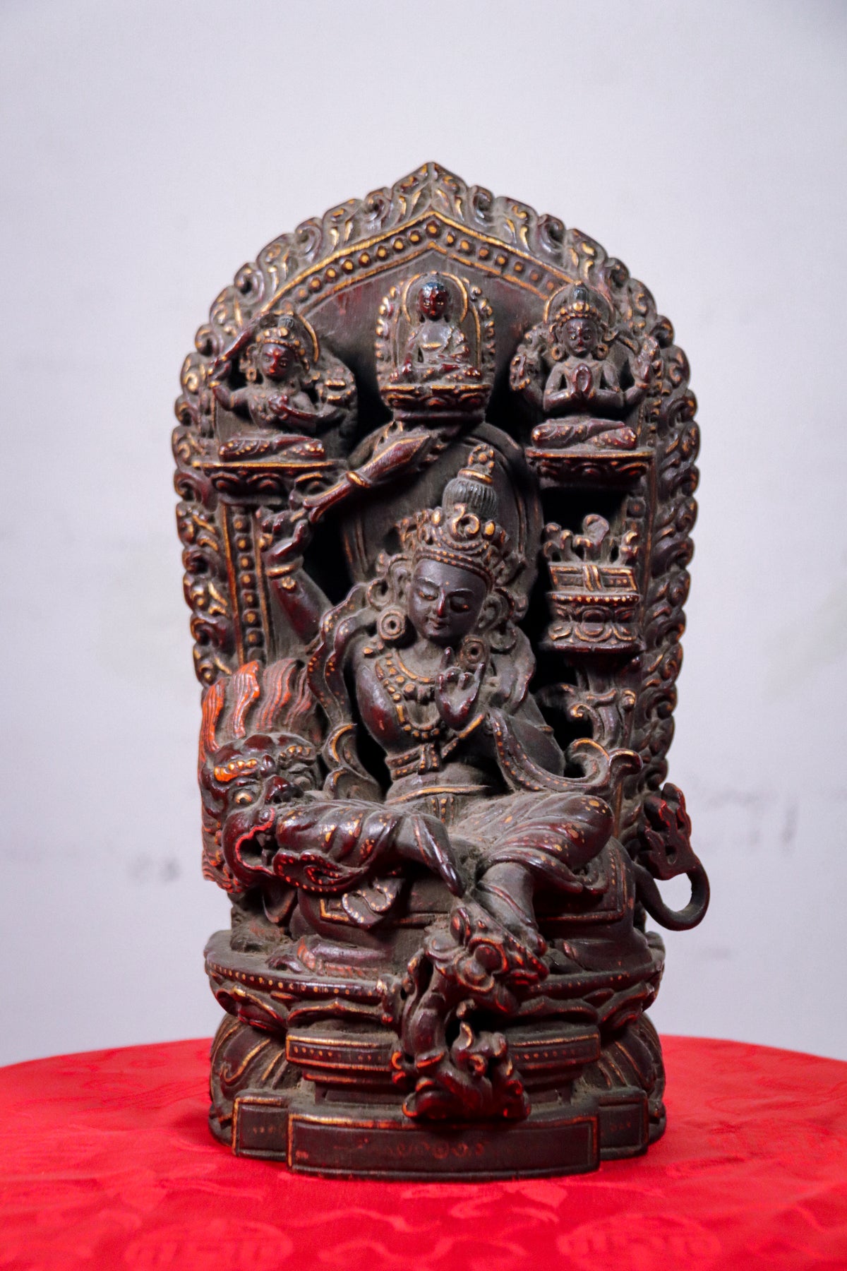 Handcrafted wooden shrine featuring Manjushri seated on a lion.